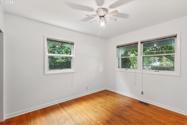 unfurnished room featuring baseboards, visible vents, a ceiling fan, and light wood-type flooring