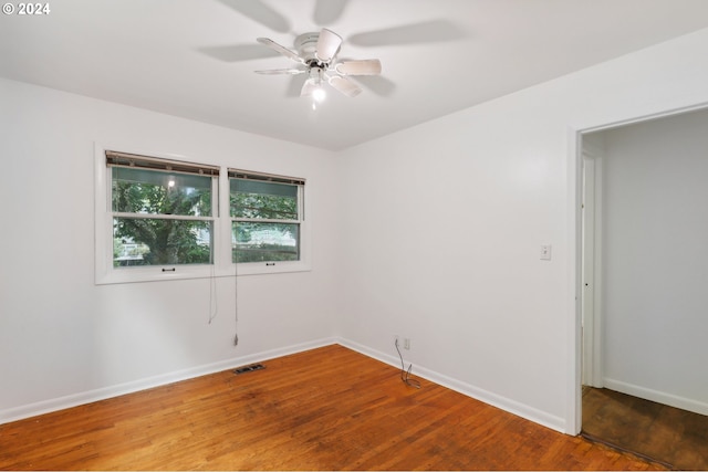unfurnished room featuring visible vents, ceiling fan, wood finished floors, and baseboards