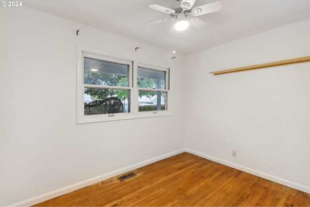 empty room with baseboards, visible vents, ceiling fan, and light wood finished floors