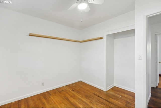 empty room with baseboards, wood finished floors, and ceiling fan