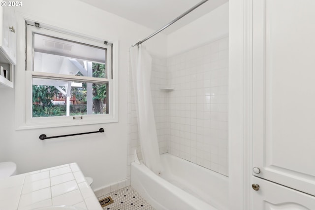 full bathroom featuring toilet, tile patterned flooring, and shower / bathtub combination with curtain