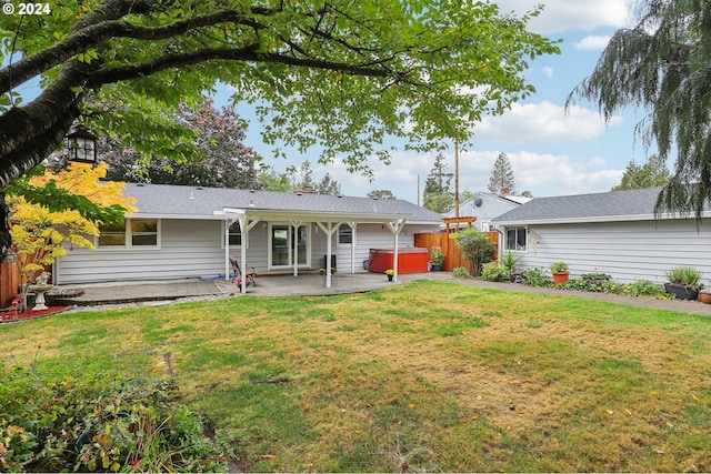 back of house with a patio area, a jacuzzi, and a yard