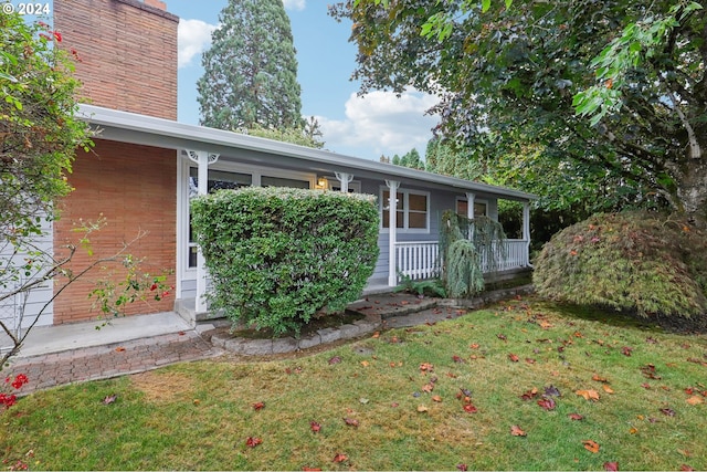 exterior space featuring covered porch and a front yard