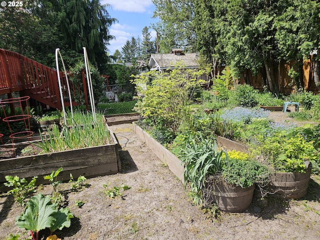 view of yard with stairway, fence, and a garden