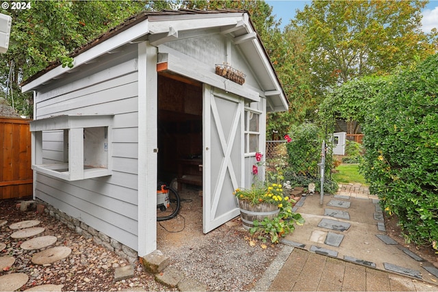 view of shed featuring fence