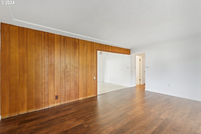 empty room featuring dark hardwood / wood-style floors and wooden walls