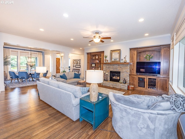 living room featuring ceiling fan, dark hardwood / wood-style flooring, ornamental molding, and a fireplace