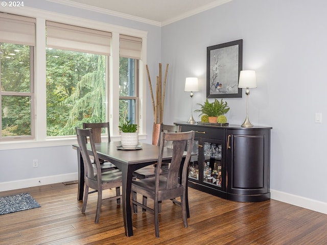 dining room with ornamental molding, dark hardwood / wood-style flooring, and a healthy amount of sunlight