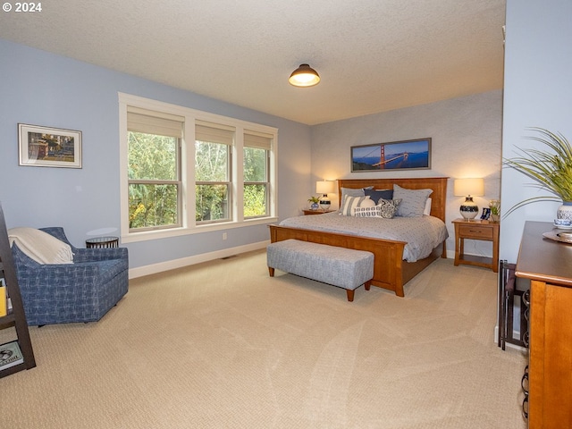 bedroom with light carpet and a textured ceiling