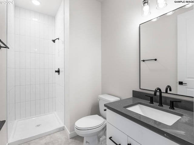 bathroom featuring vanity, toilet, and a tile shower