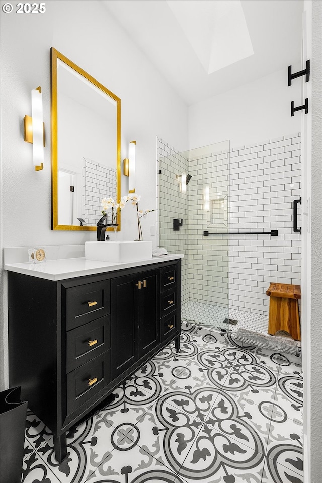 full bath with lofted ceiling with skylight, a shower stall, vanity, and tile patterned floors