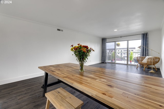 dining area featuring ornamental molding and dark wood-type flooring