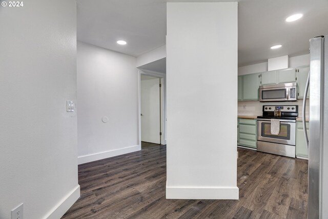 kitchen with dark wood-type flooring, stainless steel appliances, and green cabinets