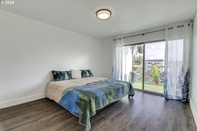 bedroom featuring access to outside, multiple windows, and dark hardwood / wood-style flooring