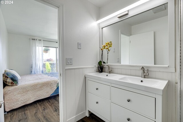 bedroom featuring ensuite bathroom and dark wood-type flooring