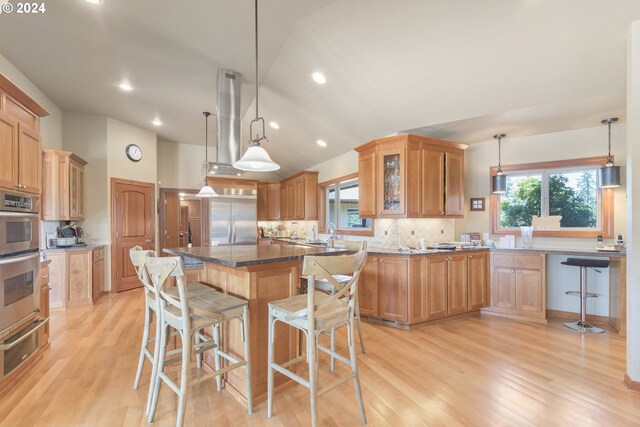 kitchen with plenty of natural light, stainless steel appliances, and a kitchen breakfast bar