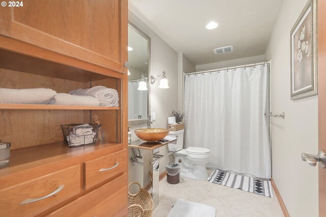 bathroom featuring tile patterned flooring, vanity, and toilet