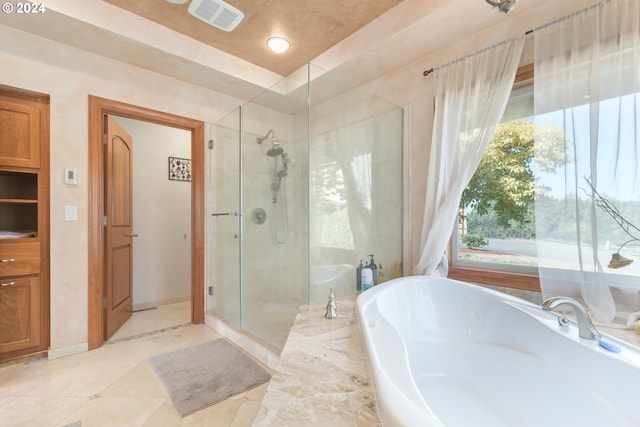 bathroom featuring tile patterned flooring and shower with separate bathtub