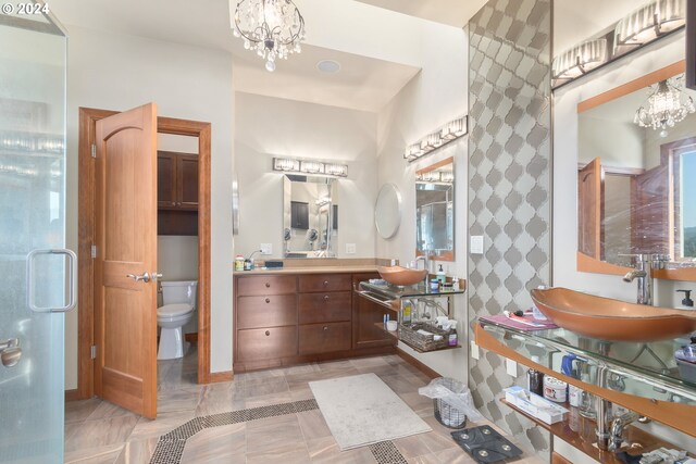 bathroom featuring toilet, an inviting chandelier, and vanity