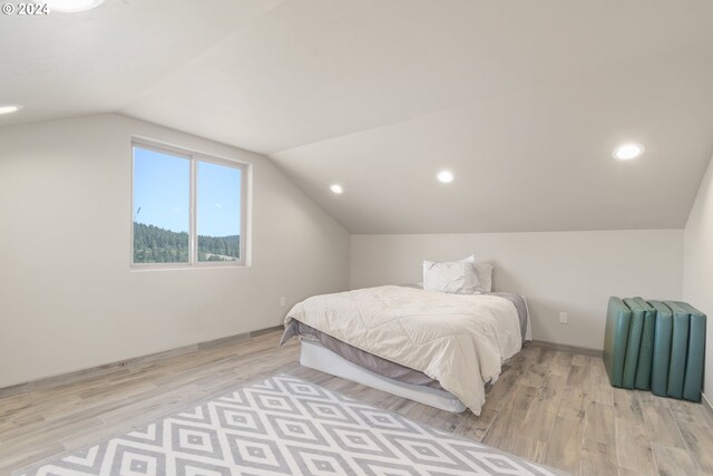 bedroom featuring light hardwood / wood-style floors and vaulted ceiling