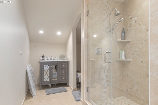 bathroom with a shower with shower door, vanity, and tile patterned floors