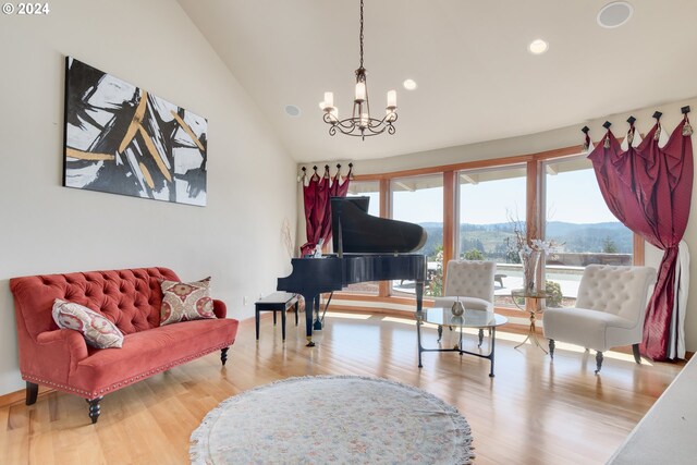 living area featuring lofted ceiling, wood-type flooring, and a chandelier