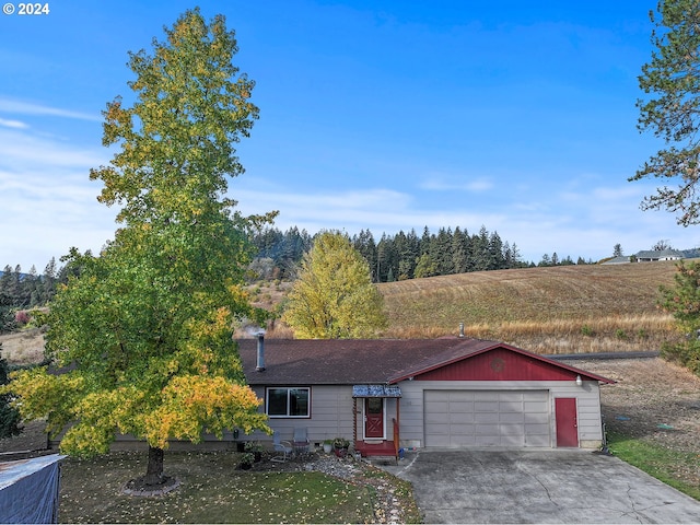 view of front of property with a garage and a rural view