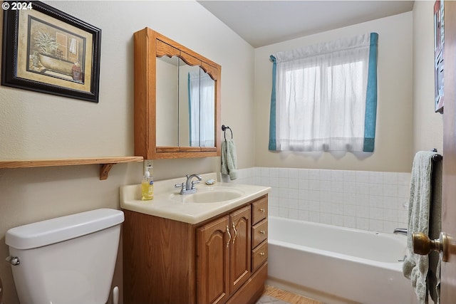 bathroom featuring a tub to relax in, vanity, and toilet