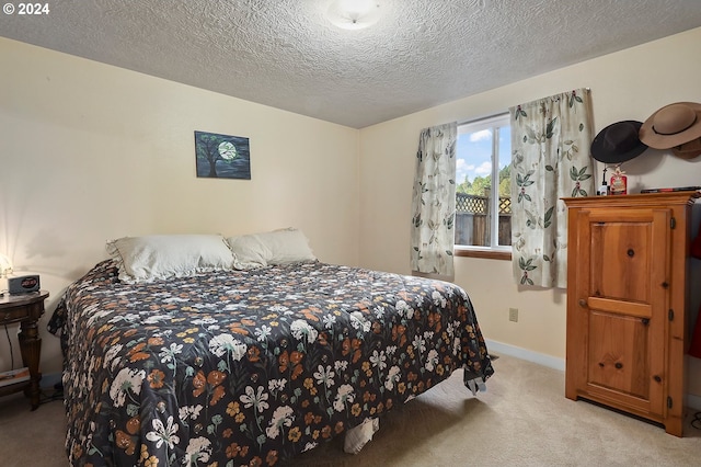 bedroom with light colored carpet and a textured ceiling