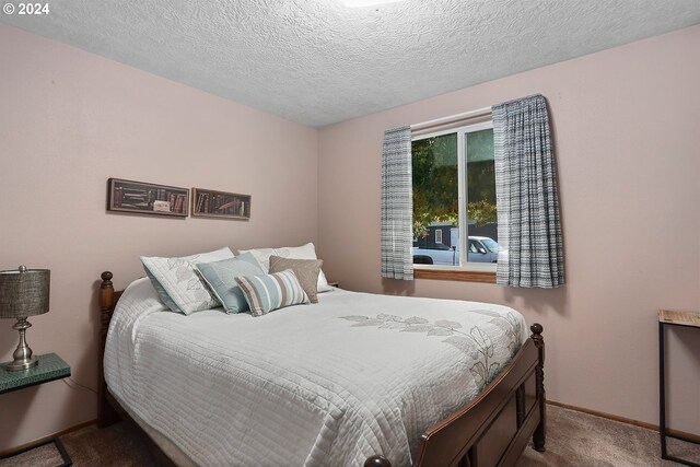 bedroom featuring carpet flooring and a textured ceiling