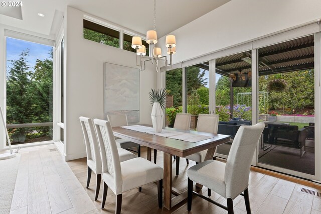 dining area with an inviting chandelier and light hardwood / wood-style floors