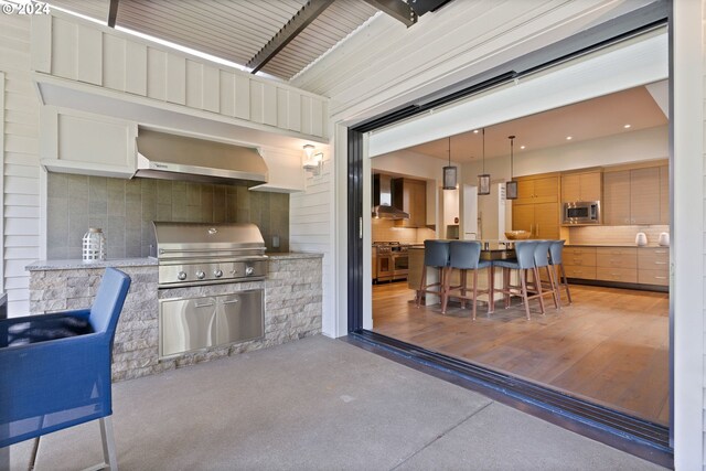 view of patio / terrace with an outdoor bar, exterior kitchen, and a grill