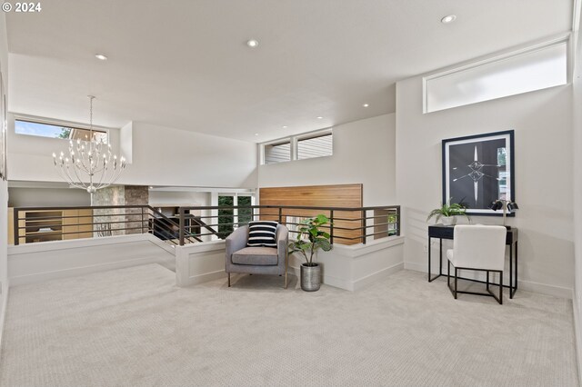 sitting room with an inviting chandelier and light carpet