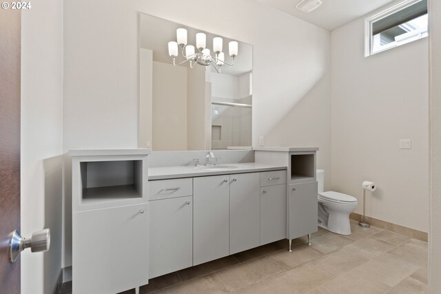 bathroom with a shower with door, tile patterned floors, toilet, vanity, and a chandelier