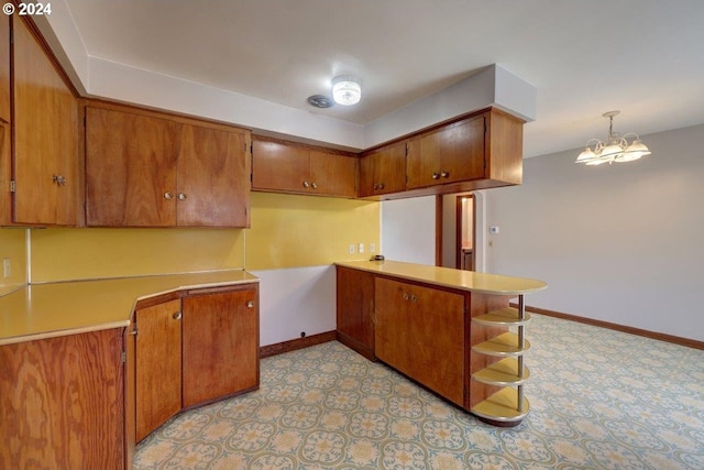 kitchen with kitchen peninsula, pendant lighting, and a notable chandelier