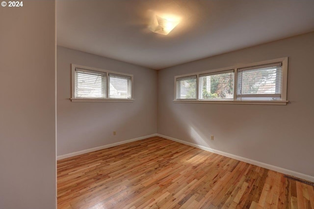 unfurnished room with plenty of natural light and light hardwood / wood-style floors