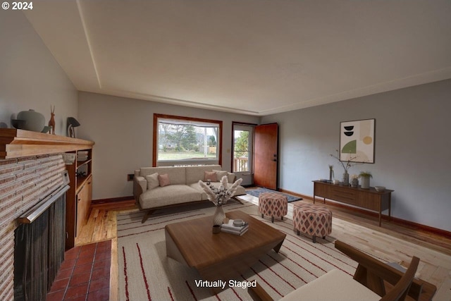 living room featuring dark hardwood / wood-style flooring and a brick fireplace