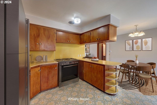 kitchen featuring a chandelier, kitchen peninsula, decorative light fixtures, and stainless steel range with gas stovetop