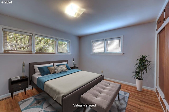 bedroom featuring light hardwood / wood-style flooring and multiple windows