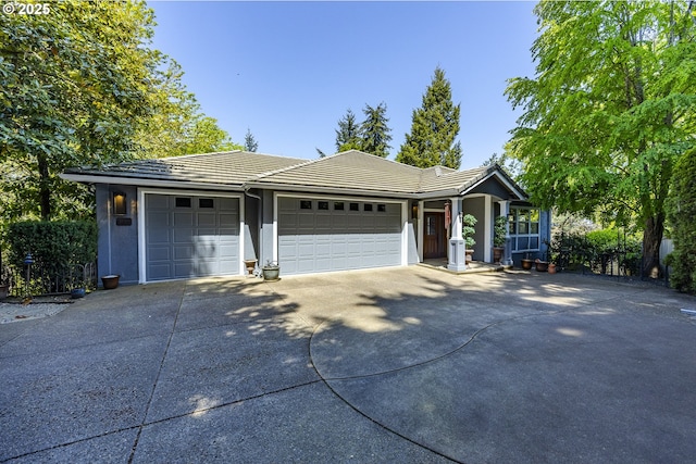ranch-style house with a garage, stucco siding, a tiled roof, and concrete driveway