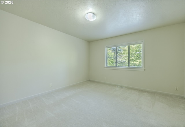 spare room with baseboards and light carpet