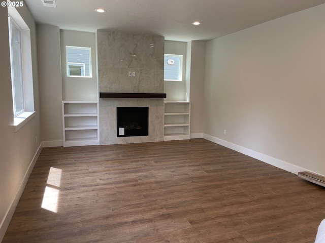 17344 SW Wapato Island Dr Unit 27, Sherwood, OR 97140 - unfurnished living room with baseboards, a tiled fireplace, recessed lighting, wood finished floors, and built in shelves