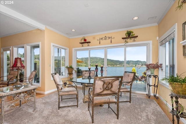 dining room featuring crown molding, hardwood / wood-style flooring, and a water and mountain view