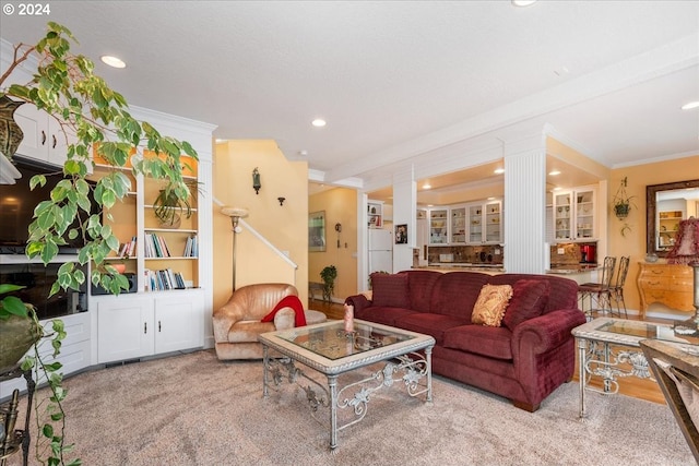 carpeted living room featuring beamed ceiling, crown molding, and ornate columns