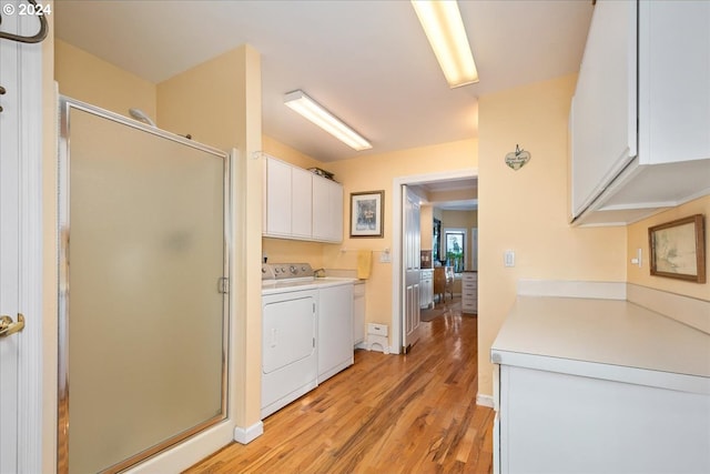 interior space featuring light wood-type flooring, independent washer and dryer, and cabinets