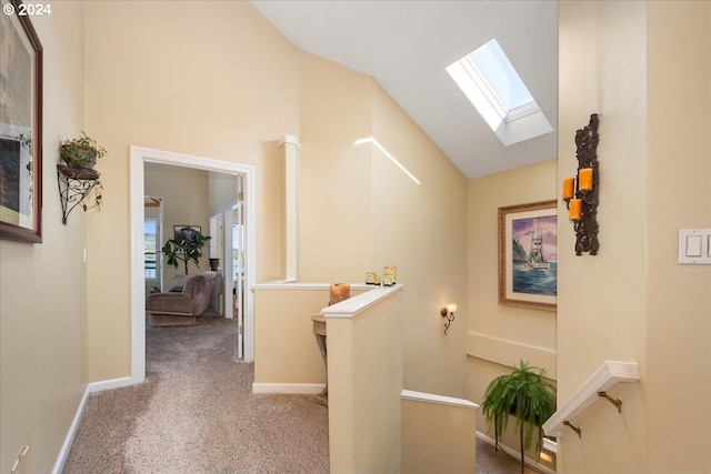 hallway featuring carpet flooring and lofted ceiling with skylight