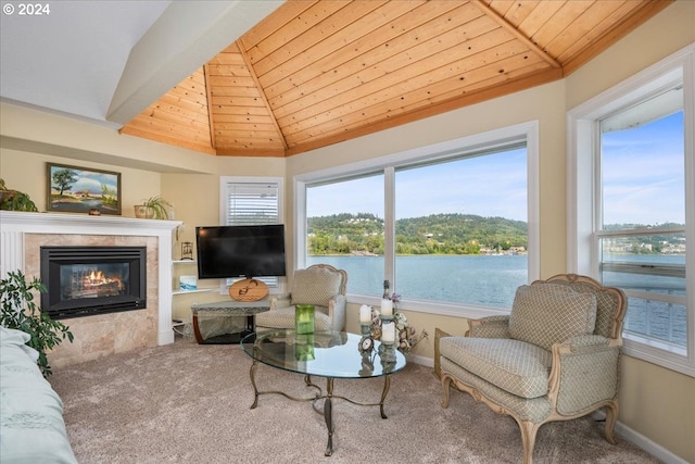 living room featuring lofted ceiling, carpet flooring, a tile fireplace, and wooden ceiling