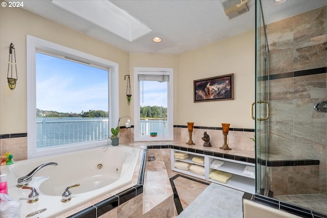 bathroom featuring a textured ceiling, separate shower and tub, and a skylight