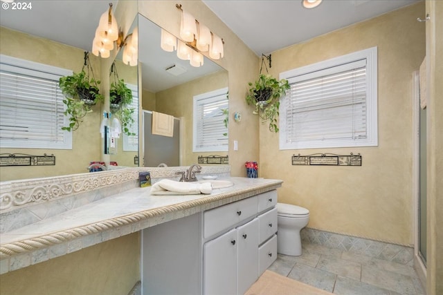 bathroom featuring tile patterned flooring, walk in shower, toilet, and vanity