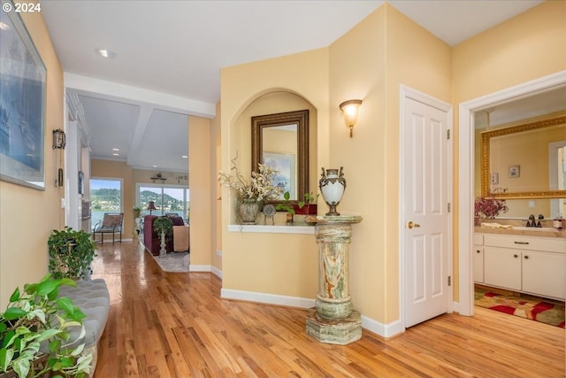 hall with sink and light hardwood / wood-style flooring